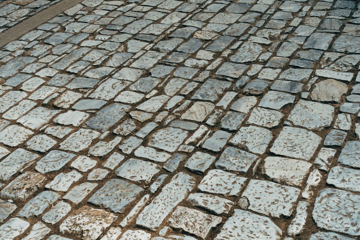 Oude granieten kasseien in rijen, met zand in de voegen